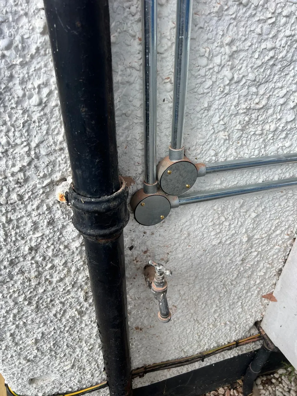 The conduit taken around the downpipe with proper bends.