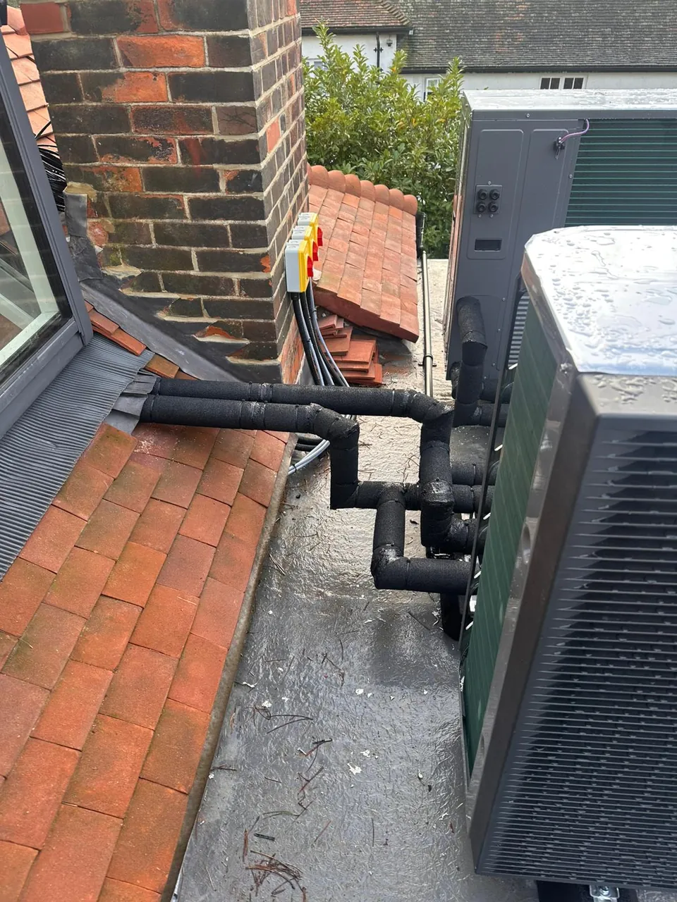 The pipework dropping from the roof, insulated and clipped along the wall.