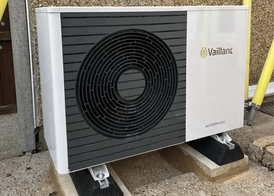 The smaller aroTHERM plus on its feet against the house wall.