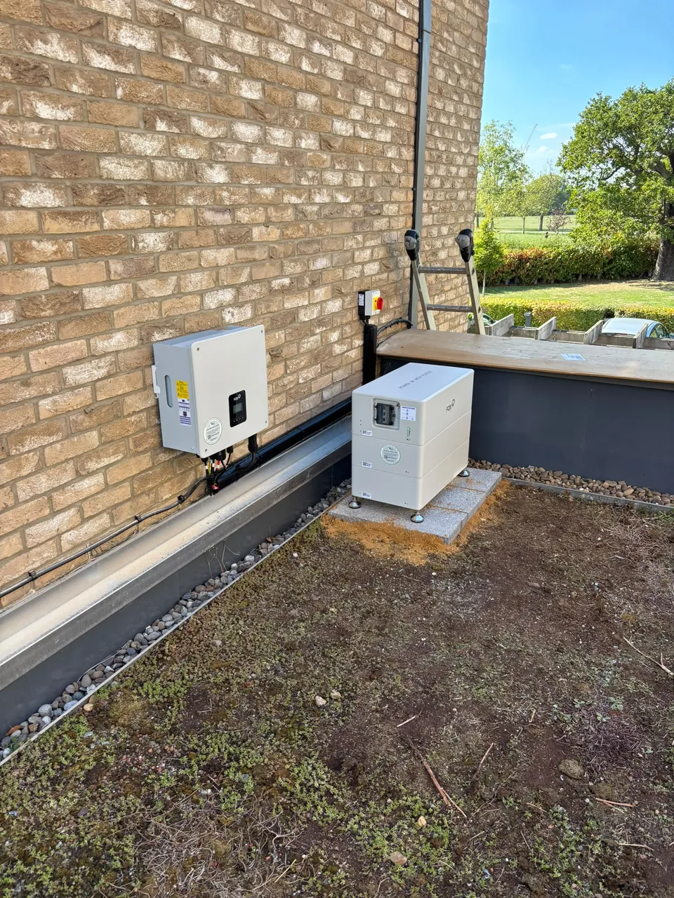 The same wall from across the terrace: inverter above, battery below.