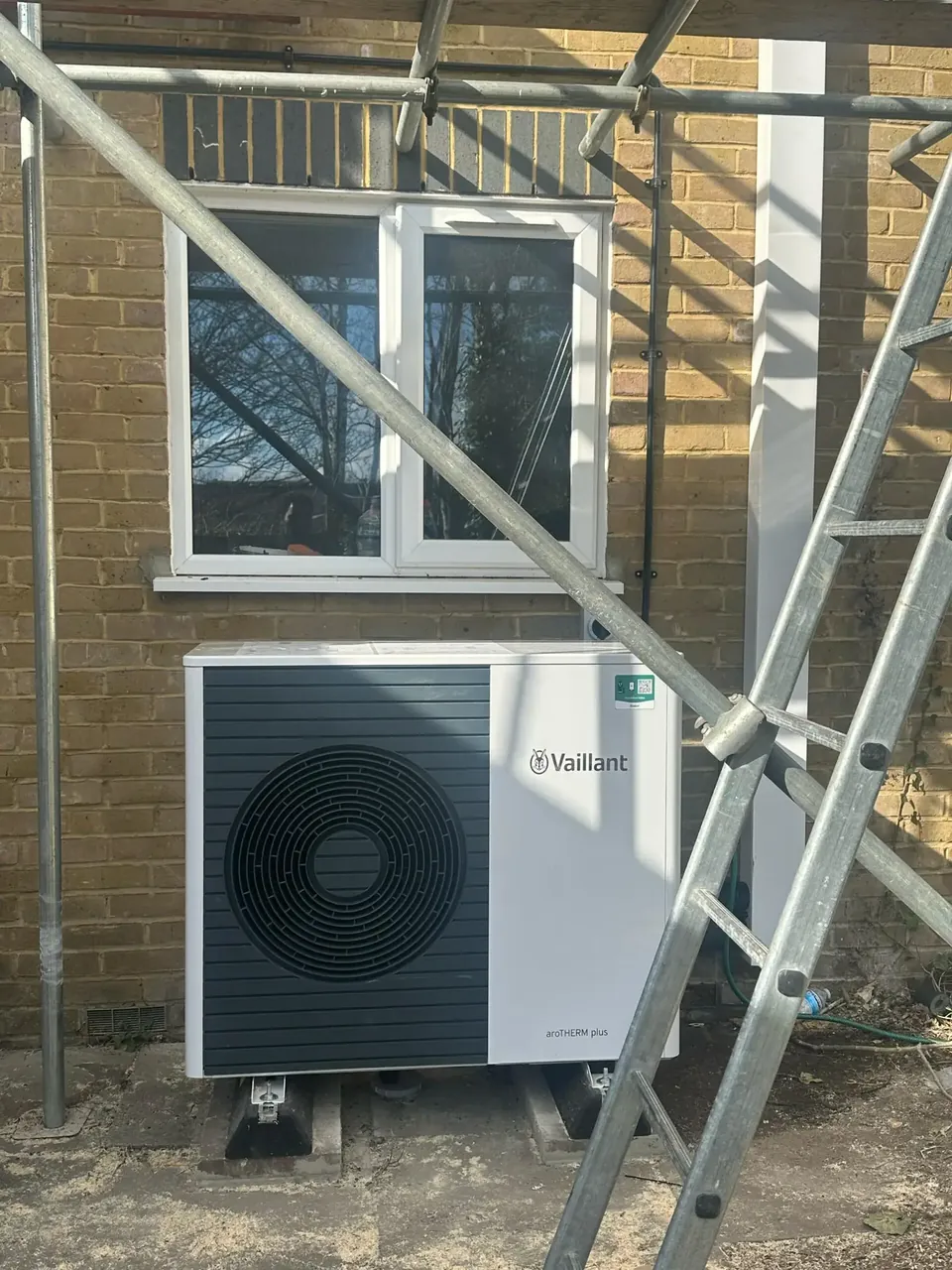The aroTHERM plus on raised feet against the rear wall, while the scaffold was still up for the panels.