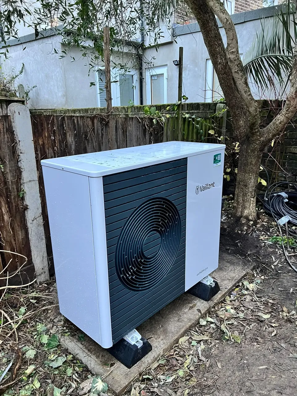 The outdoor unit on its own base in the garden.