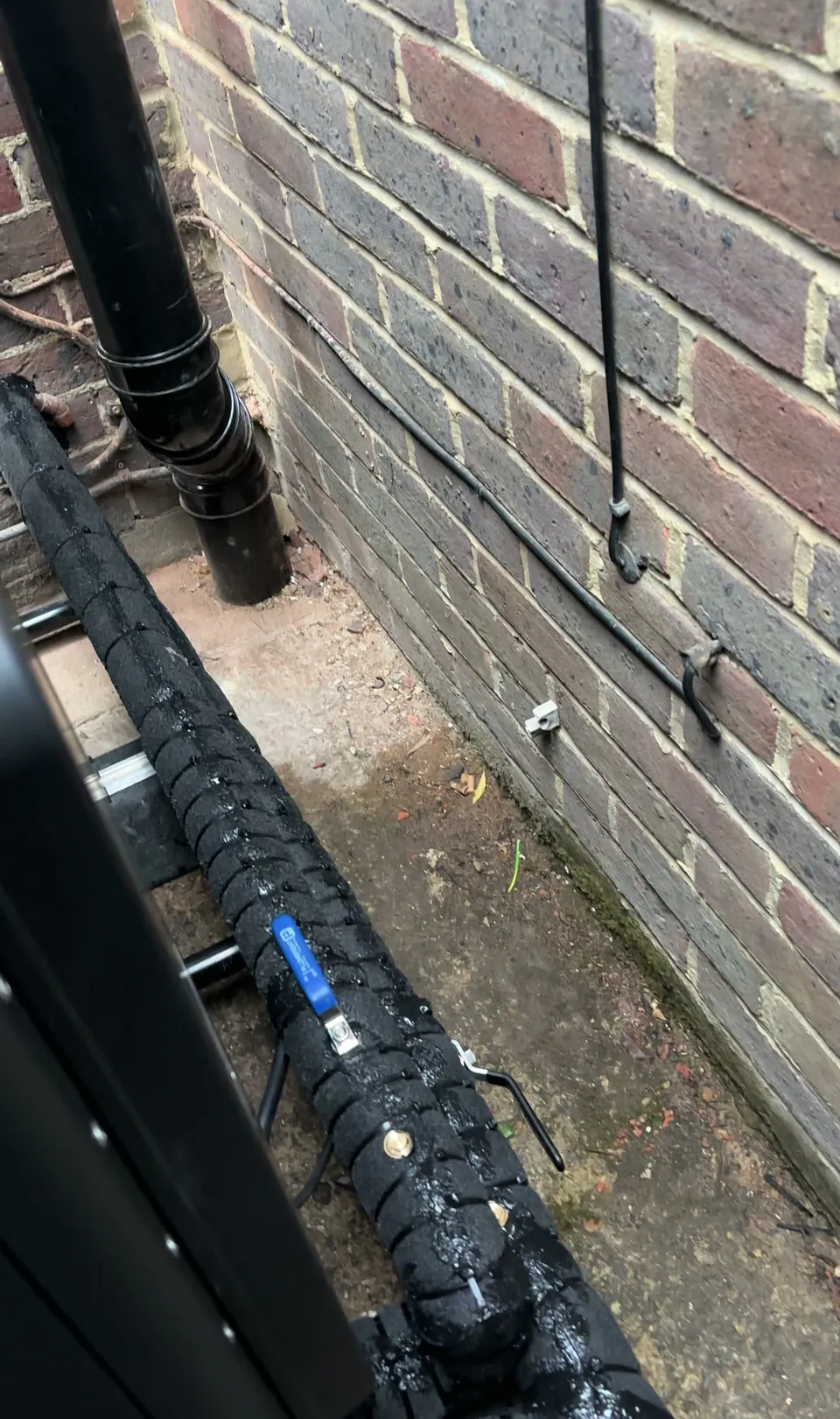 Flow and return in thick black insulation along the foot of the wall.