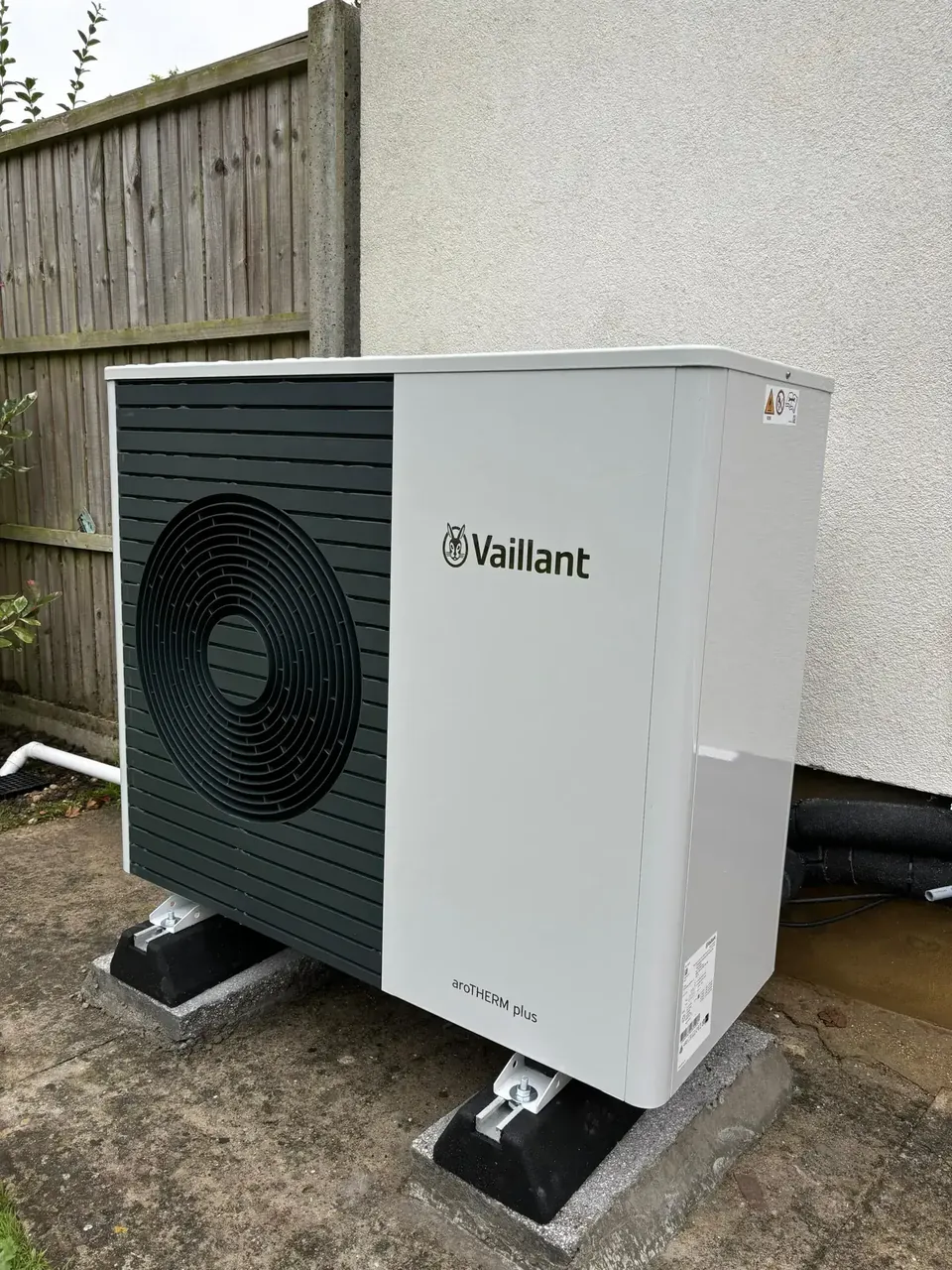 The aroTHERM plus on anti-vibration feet on a concrete pad close to the house.
