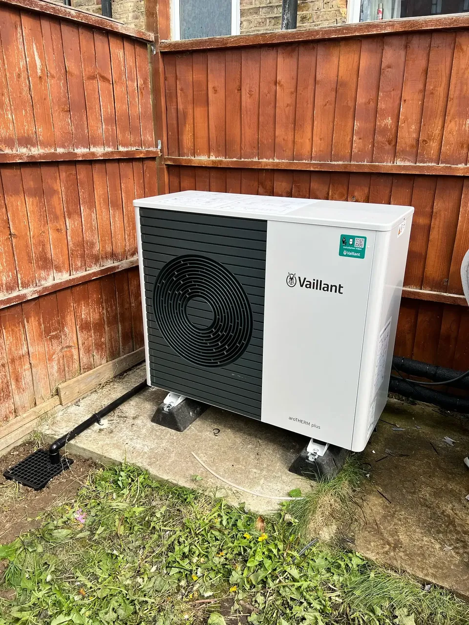 The aroTHERM plus in the corner of the garden, raised off the ground.