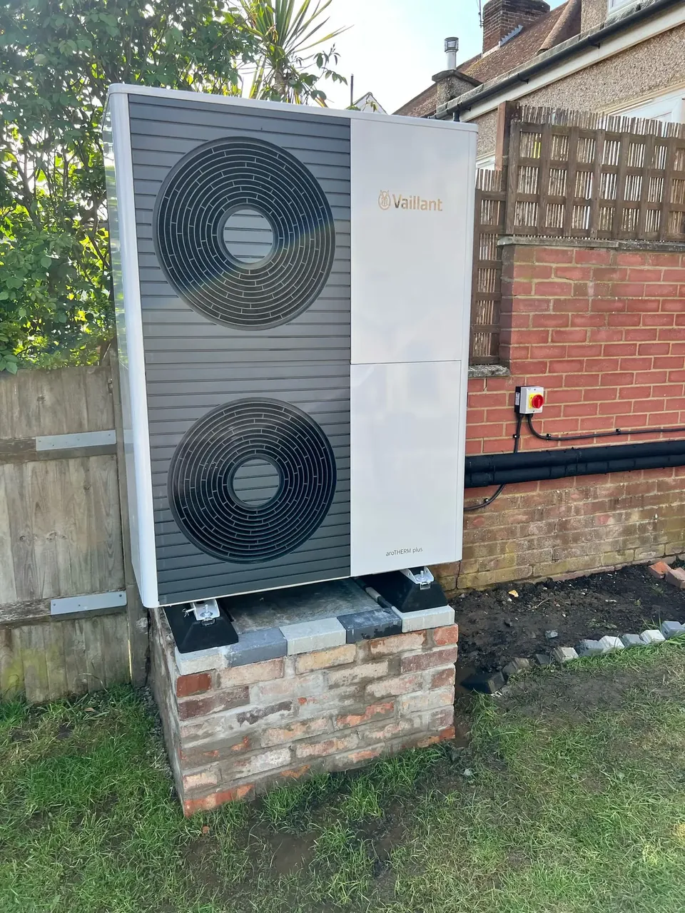 The twin-fan unit raised on a brick plinth.