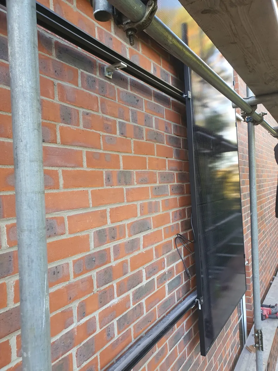 A panel and its rail on the brickwork, seen from the scaffold.