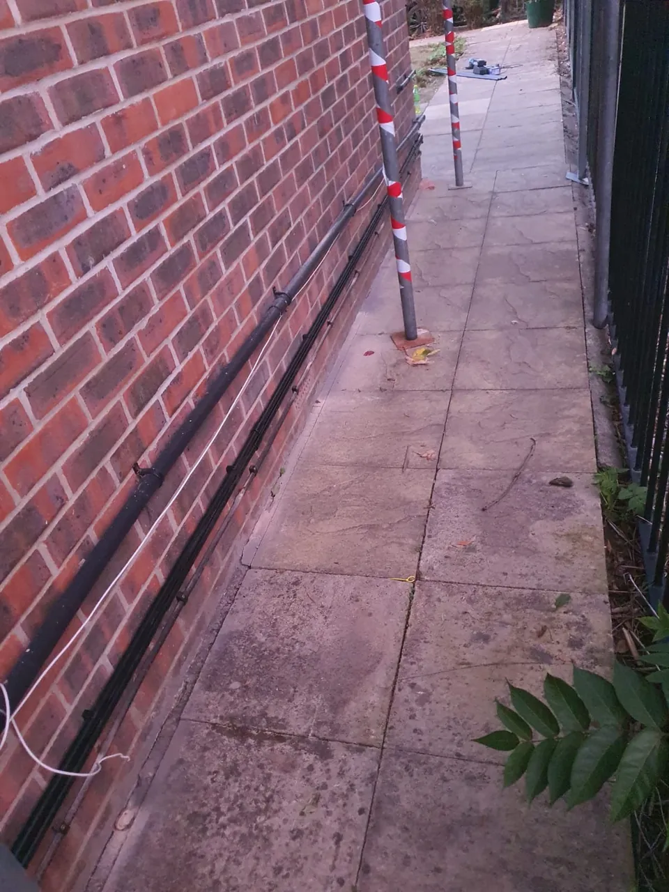The cable in black trunking along the foot of the wall in the side passage.