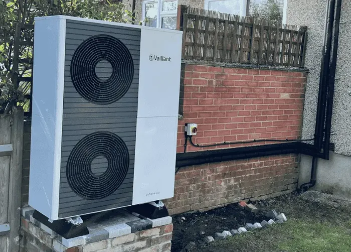 Air source heat pump outdoor unit installed beside a house